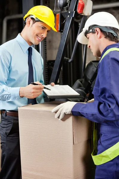 Supervisor masculino mostrando prancheta para Foreman — Fotografia de Stock