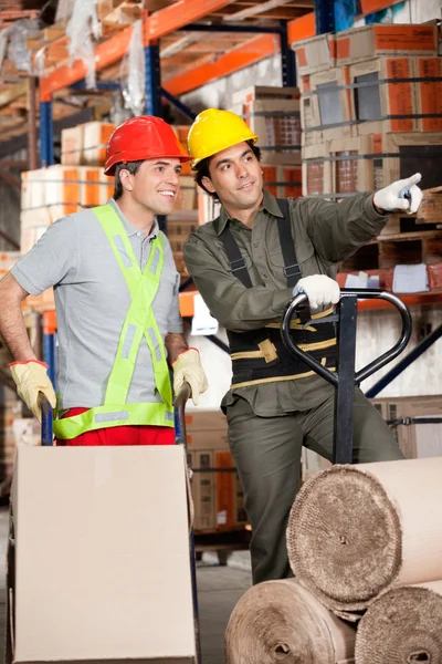 Foreman mostrando algo para colega de trabalho no armazém — Fotografia de Stock