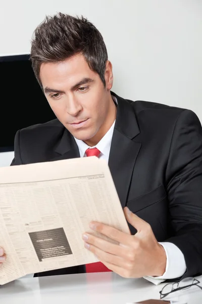 Empresário lendo jornal no escritório — Fotografia de Stock