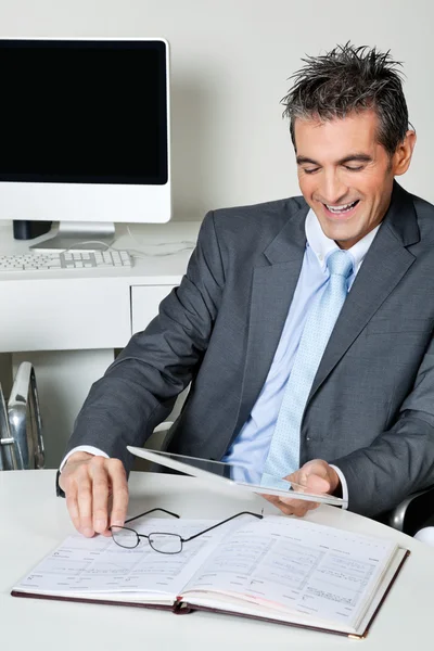 Homme d'affaires heureux en utilisant une tablette numérique au bureau — Photo
