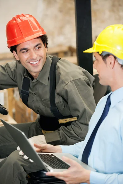 Supervisor und Gabelstaplerfahrer mit Laptop lizenzfreie Stockfotos