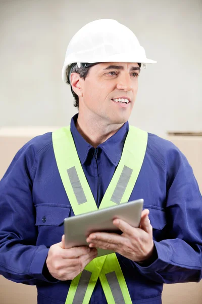 Foreman met digitale tablet staande in magazijn — Stockfoto