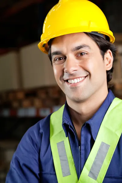 Schöner Vorarbeiter lächelt in Lagerhalle — Stockfoto