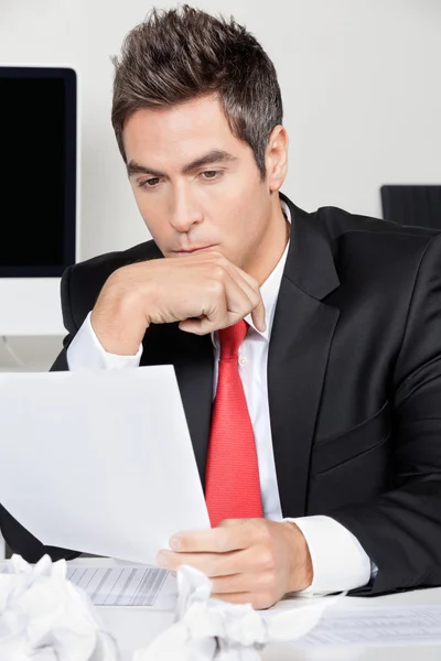 Homme d'affaires réfléchi lisant le document au bureau — Photo