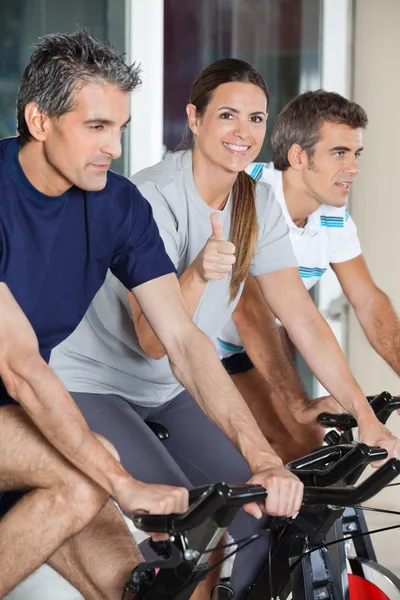 Frau zeigt Daumen nach oben Zeichen beim Training mit Freunden auf sp — Stockfoto