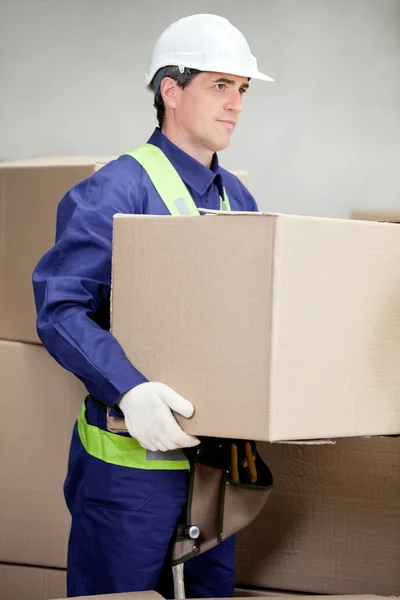 Capataz levantar la caja de cartón en almacén — Stockfoto