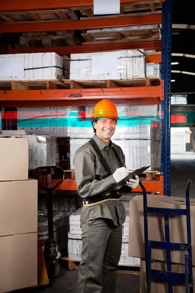 Supervisor escribiendo en portapapeles en el almacén — Foto de Stock