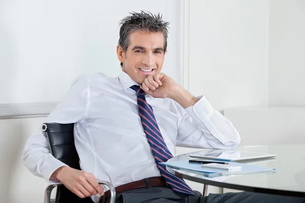Счастливый бизнесмен отдыхает в офисе — стоковое фото