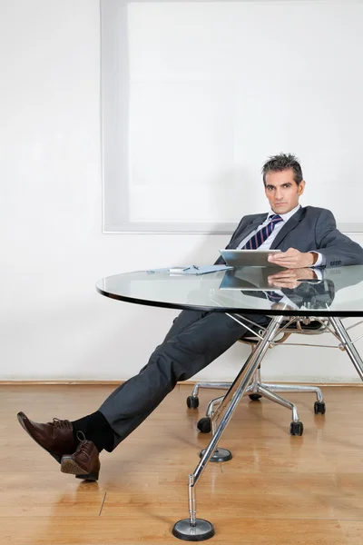 Розслаблений бізнесмен використовуючи цифровий планшет в офісі — стокове фото