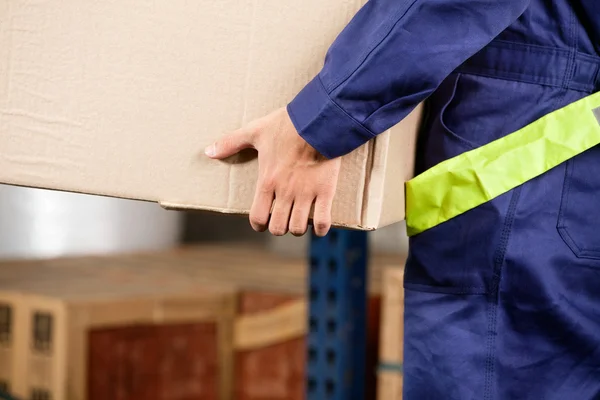 Foreman transportando caixa de papelão no armazém — Fotografia de Stock
