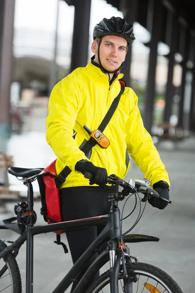 Mladý muž cyklista s taškou — Stock fotografie