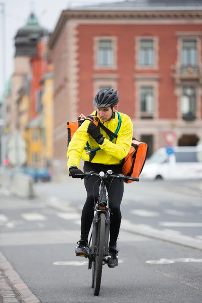 Fietser met courier tas met behulp van walkie-talkie — Stockfoto