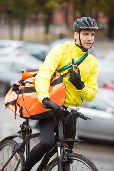 Ciclista maschio con borsa corriere utilizzando Walkie-Talkie — Foto Stock