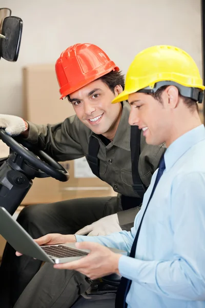 Conductor de carretilla elevadora con supervisor usando computadora portátil — Foto de Stock