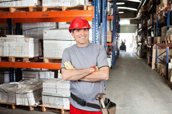 Mittlerer erwachsener Vorarbeiter mit verschränkten Armen im Lager — Stockfoto