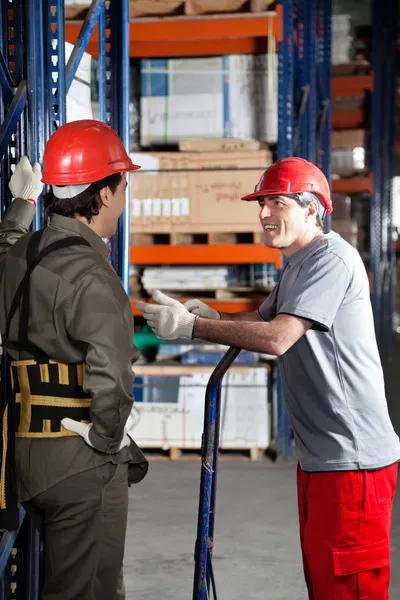 Foreman se comunicando com o colega de trabalho no armazém — Fotografia de Stock