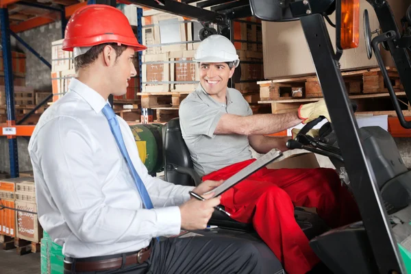 Motorista de empilhadeira se comunicando com o supervisor — Fotografia de Stock