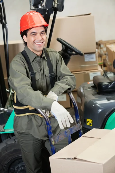 Contremaître penché sur Handtruck à l'entrepôt Photo De Stock