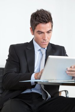 Genç işadamı ofiste dijital tablet kullanıyor