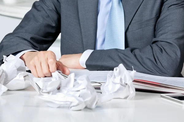 Businessman Sitting At Desk With Crumpled Papers — Stock Photo, Image