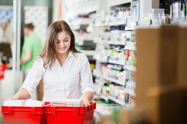 Apotheker sortiert Regale in Apotheke — Stockfoto