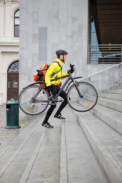 Courier levering man met fiets en rugzak wandelen trap — Stockfoto