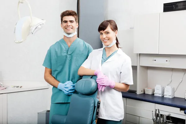 Twee tandartsen glimlachen door tandheelkundige kliniek stoel — Stockfoto
