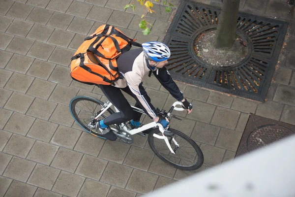 Muž cyklista s batohem na chodníku — Stock fotografie