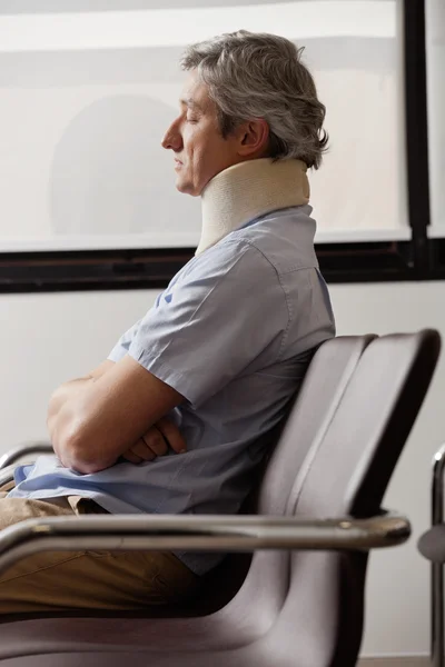 Mann mit Nackenverletzung ruht in Lobby — Stockfoto