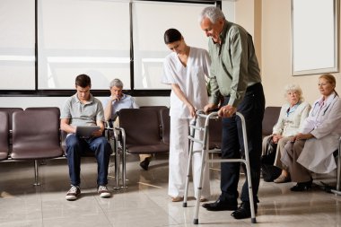 Man Being Helped By Nurse To Walk Zimmer Frame clipart