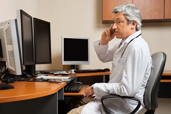 Лікар відвідує телефонний дзвінок у клініці — стокове фото
