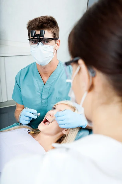 Dentista e Assistente Feminina Tratando um Paciente na Clínica — Fotografia de Stock