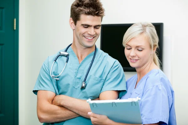 Young Female Nurse Showing Clipboard To Male Vet Stock Picture