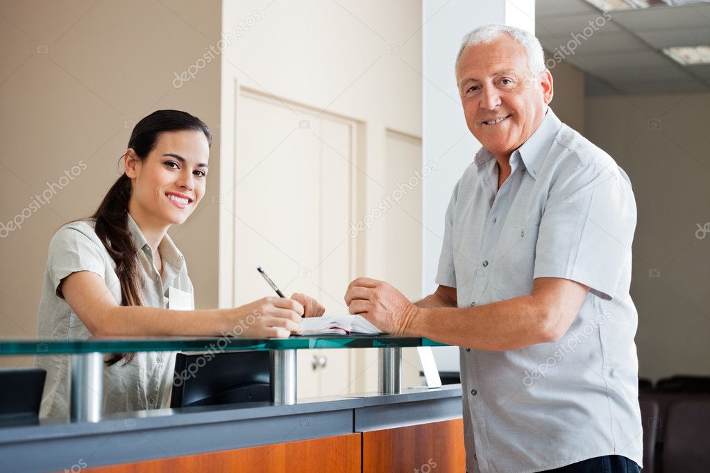 Senior Man Standing At Hospital Reception