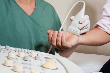 Technician Scanning Male Patient's Hand clipart
