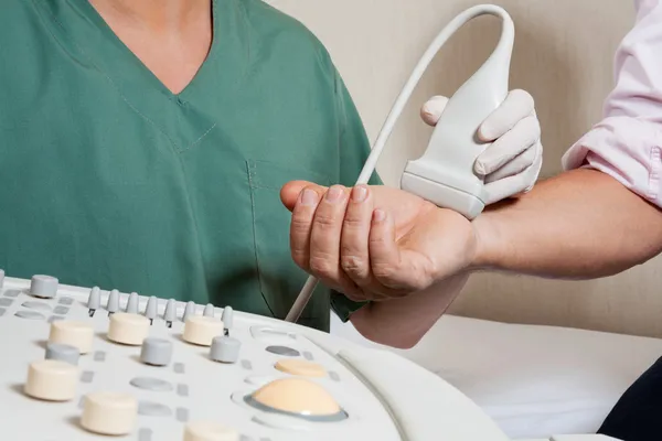 Техник сканирования мужской руки пациента — стоковое фото