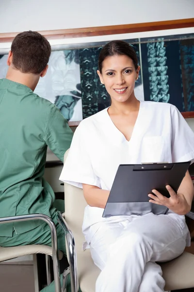 Técnico médico femenino sosteniendo portapapeles —  Fotos de Stock