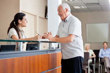 Man Communicating With Female Receptionist clipart