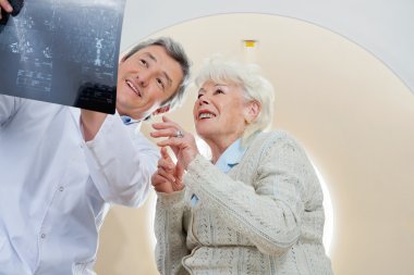 Doctor With Patient Looking At MRI X-ray clipart