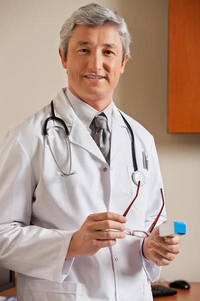 Médico Segurando óculos e caixa de medicina — Fotografia de Stock