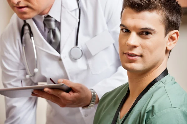 Técnico masculino com médico no fundo — Fotografia de Stock