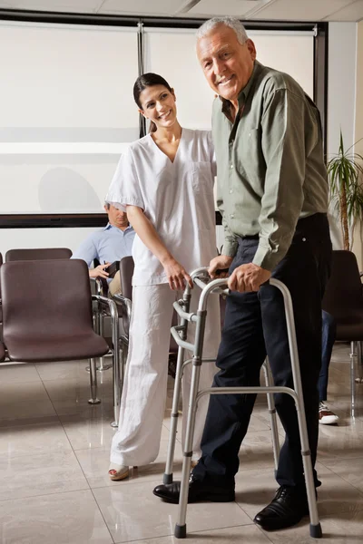 Vrouwelijke verpleegster senior patiënt helpen met walker — Stockfoto