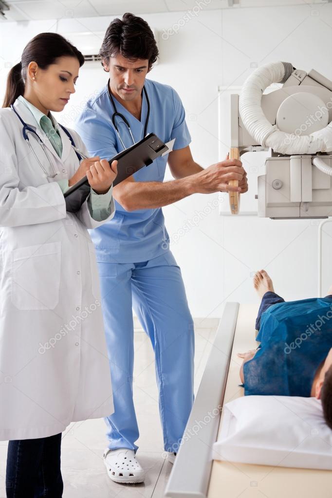 Radiologists With Patient In X-ray Room