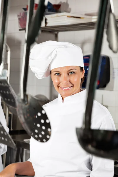 Chef feminino com colheres penduradas em primeiro plano — Fotografia de Stock