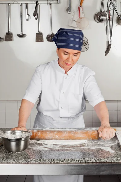 Feminino Chef Rolling Dough no balcão da cozinha — Fotografia de Stock