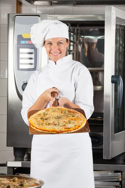 Chef femenino confiado presentando pizza — Foto de Stock
