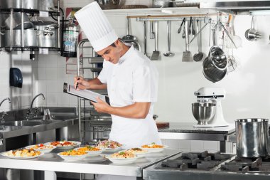 Chef With Clipboard Going Through Cooking Checklist clipart