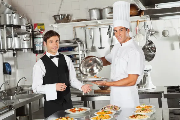 Ober nemen van klant voedsel van chef-kok — Stockfoto