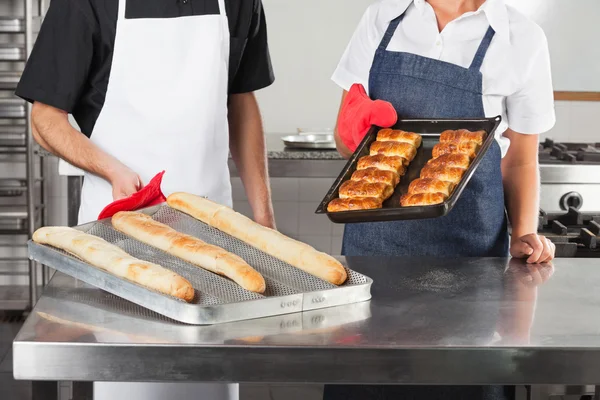 Chefs sosteniendo bandejas de pan horneado —  Fotos de Stock