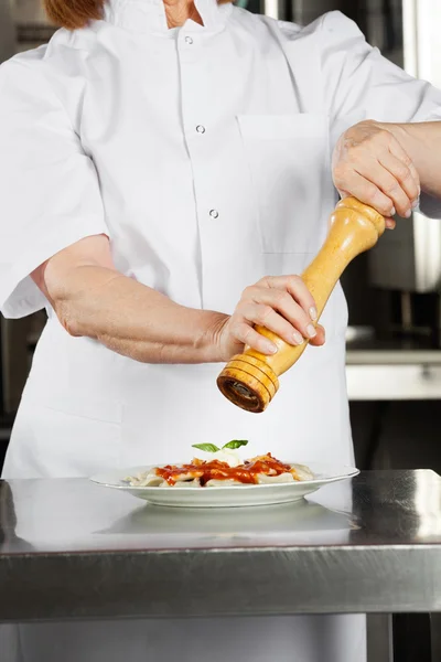 Plato de condimento de chef femenino con pimienta — Foto de Stock